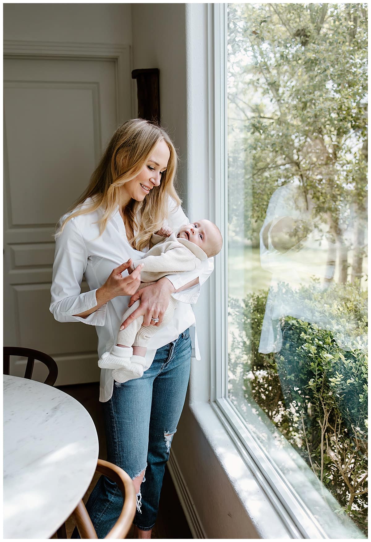 Mom stares down at baby during their In-Home Newborn Session
