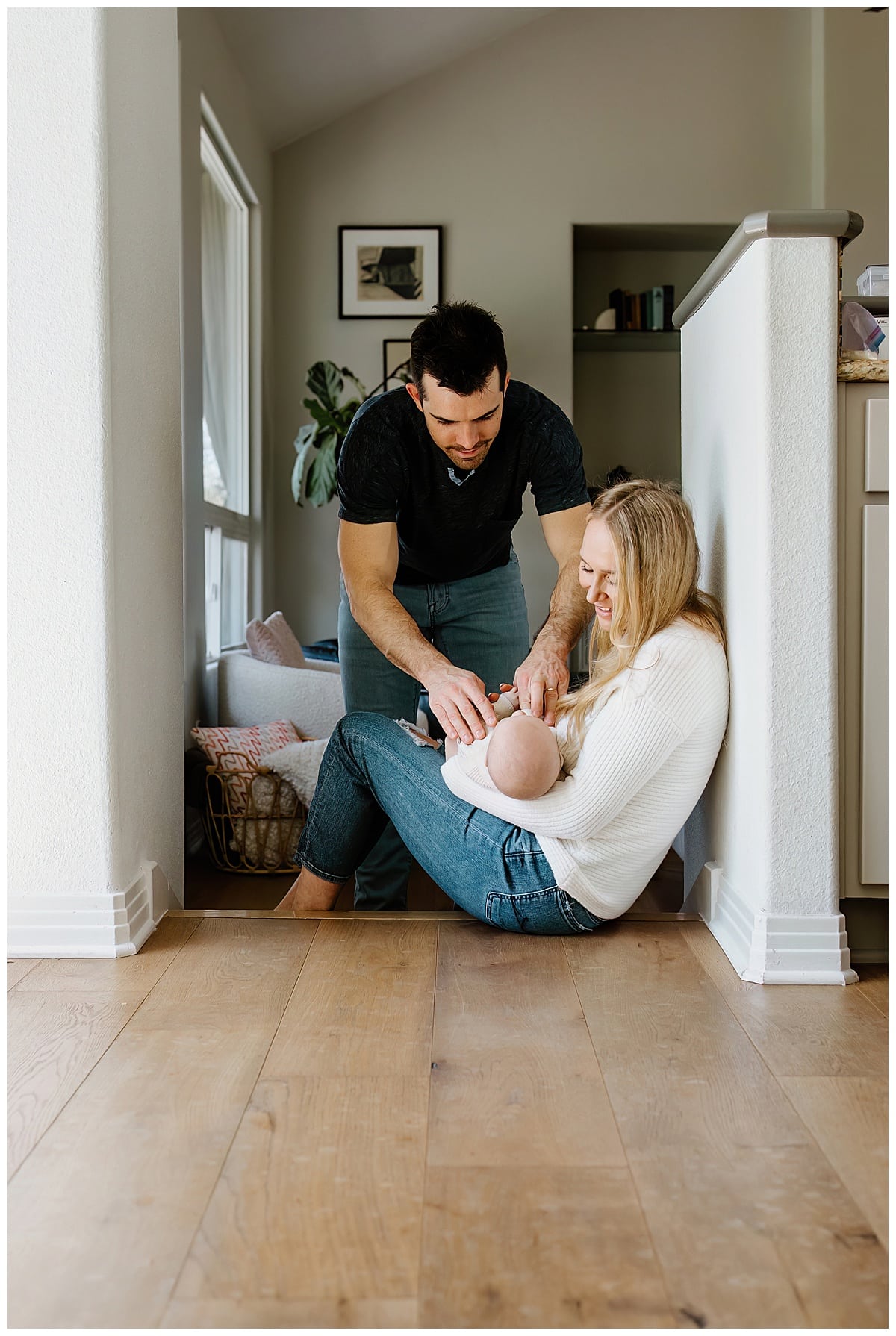 Mom and dad laugh and smile with baby for In-Home Newborn Session