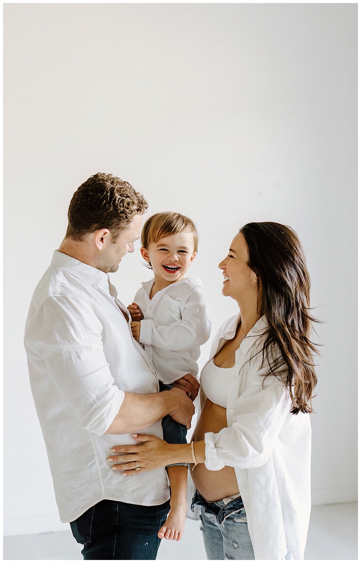 Parents love on their baby boy during their Studio Maternity Photos