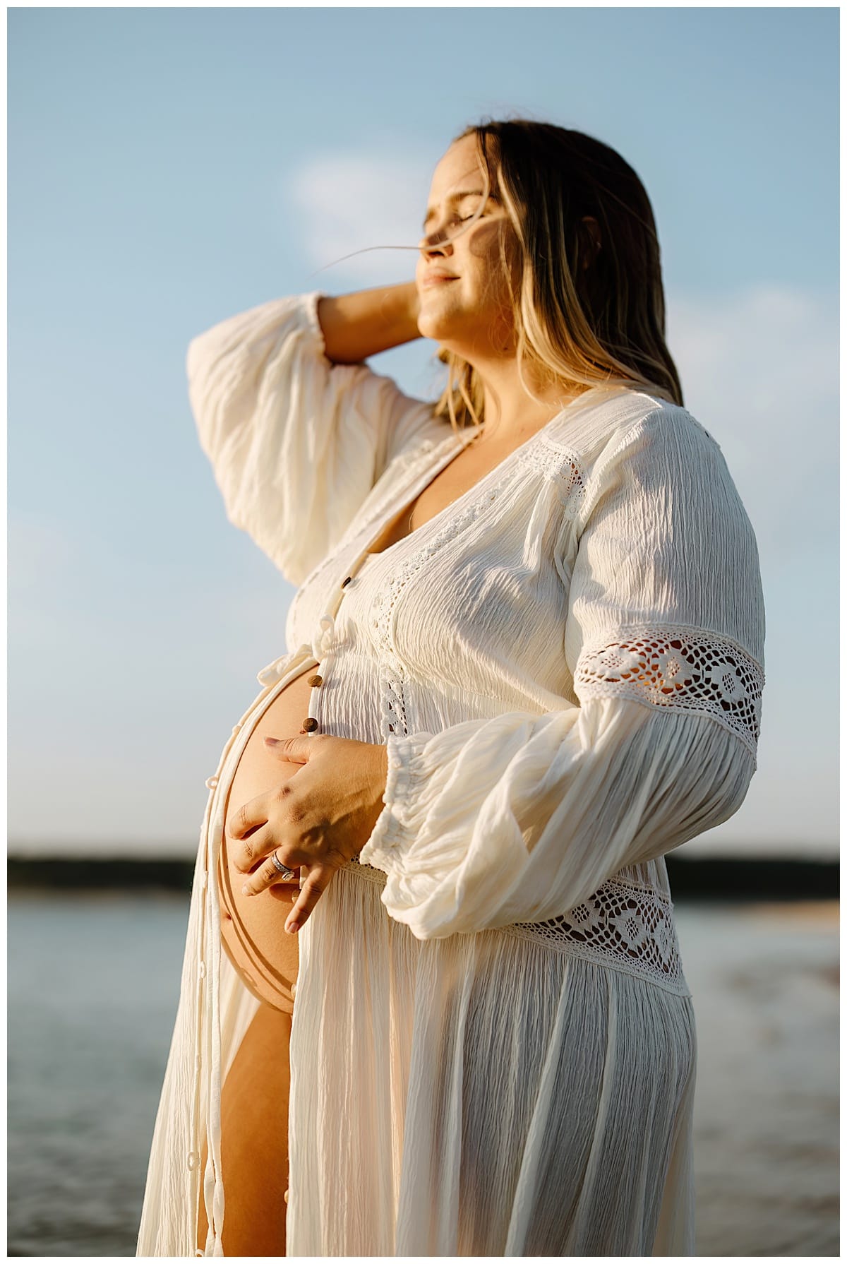 Mom holds hands on pregnant belly during Sandy Beach Maternity Session