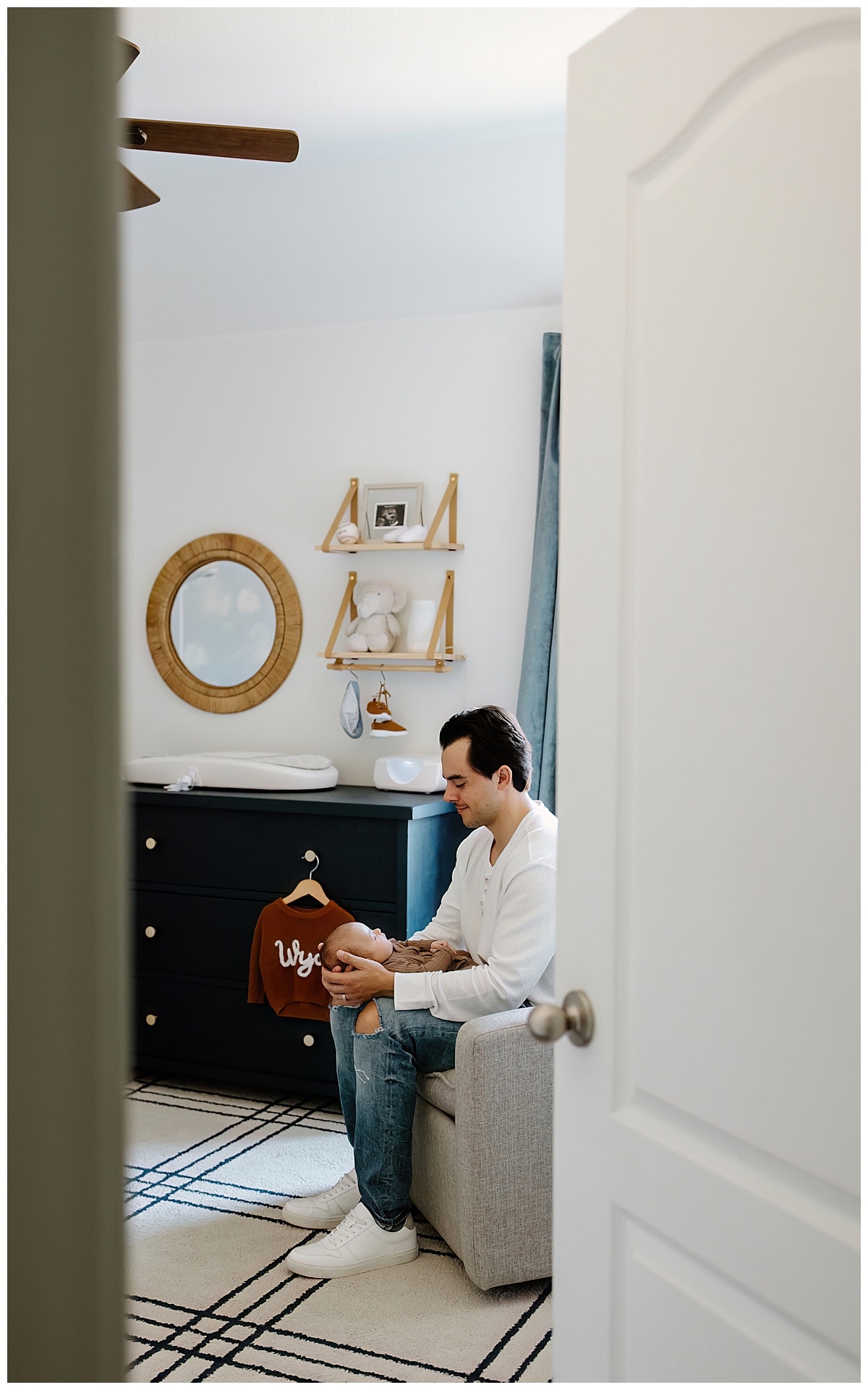 After Preparing For Your Newborn Storytelling Session Dad sits and enjoys tender moments with son 