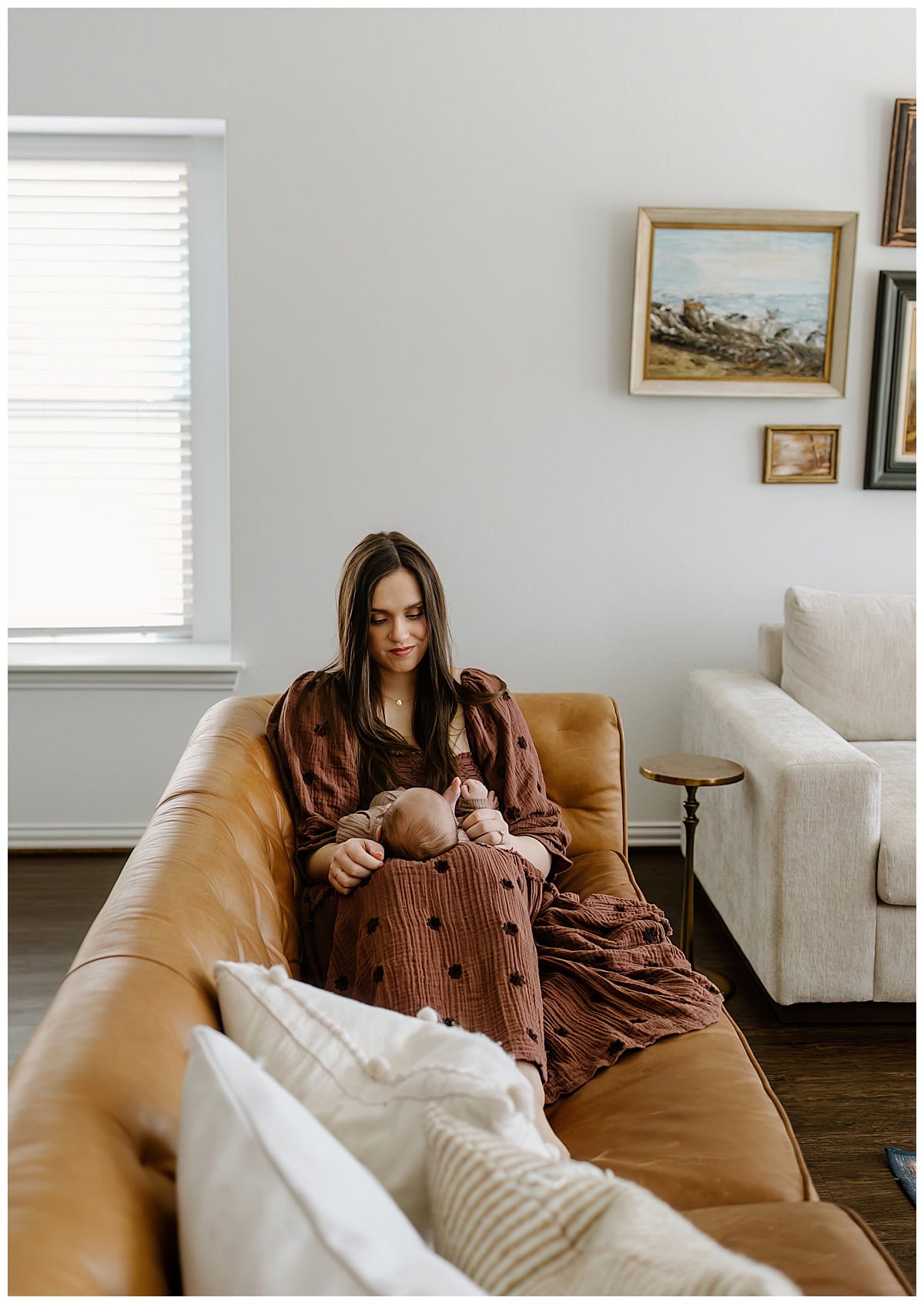 After Preparing For Your Newborn Storytelling Session Mom holds baby close on the couch