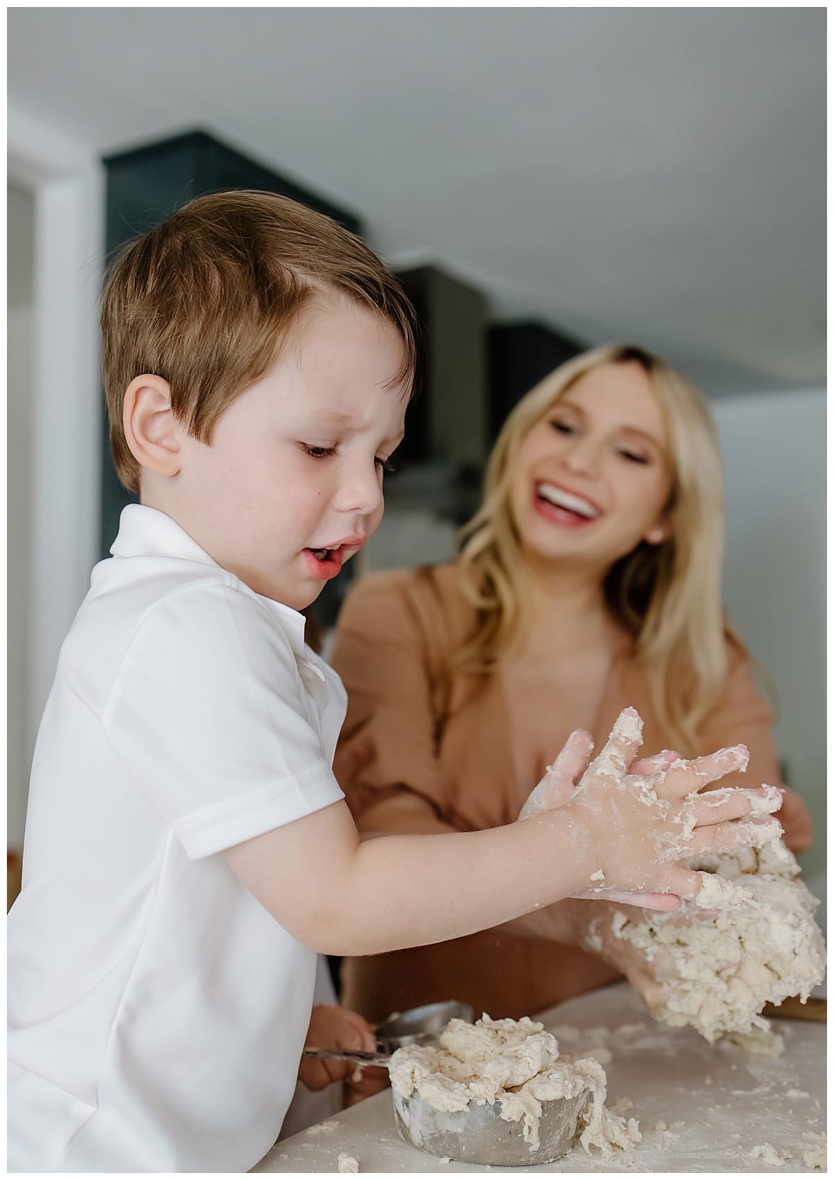 Son and mom laugh and smile together during their in home maternity session