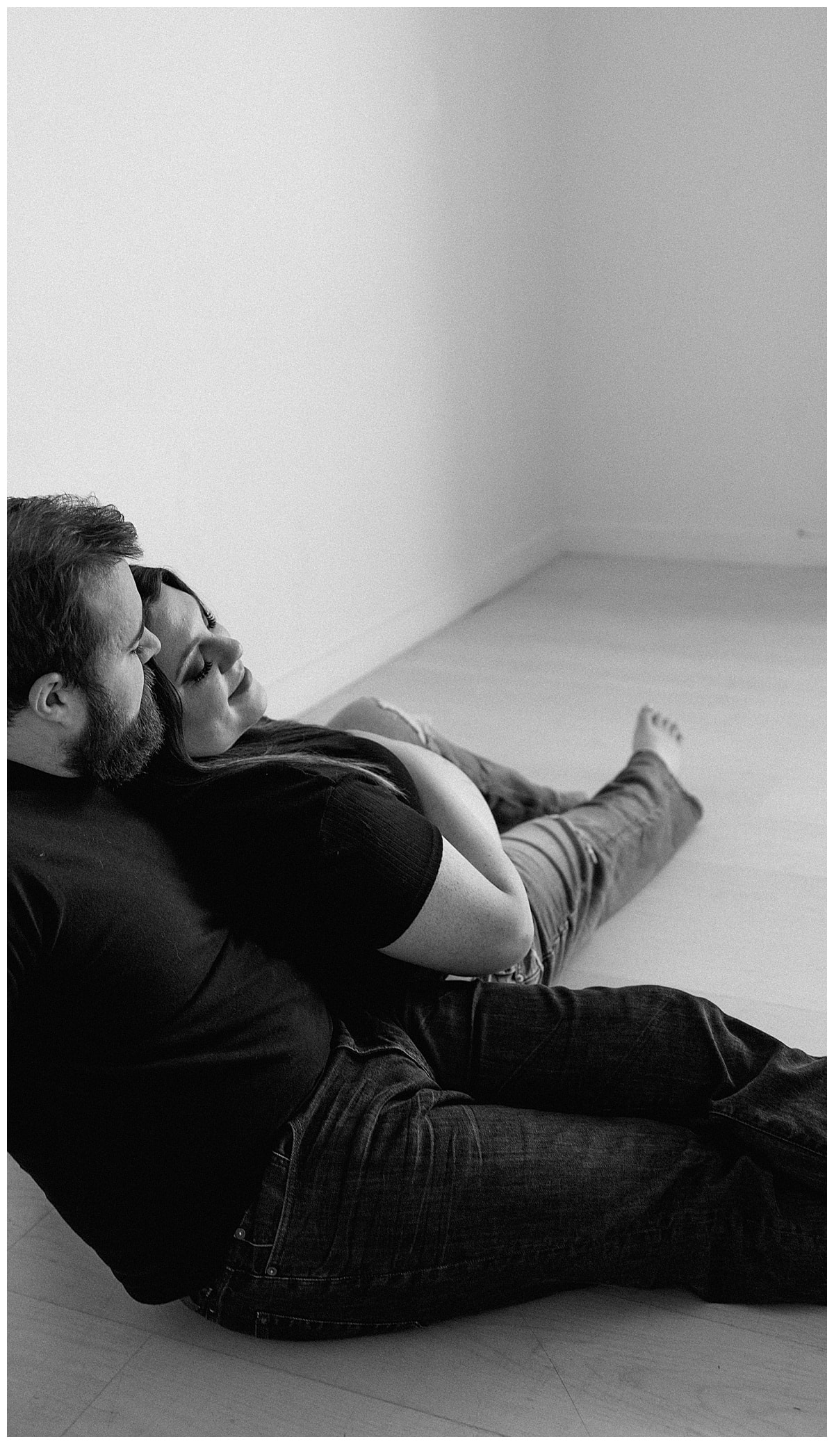 Woman lays into a man on the floor for her studio maternity session