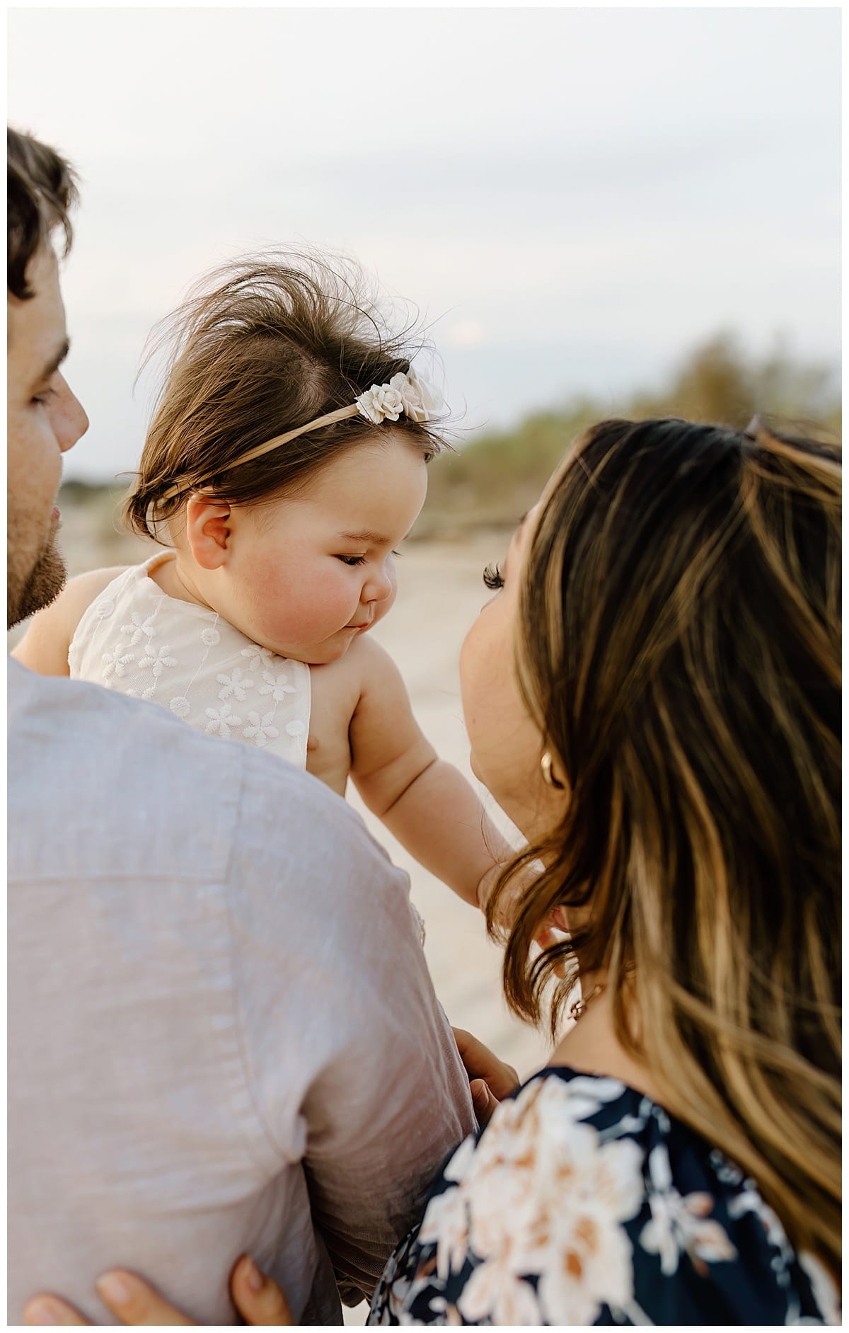 Parents smile with their baby for First Birthday Family Photos 