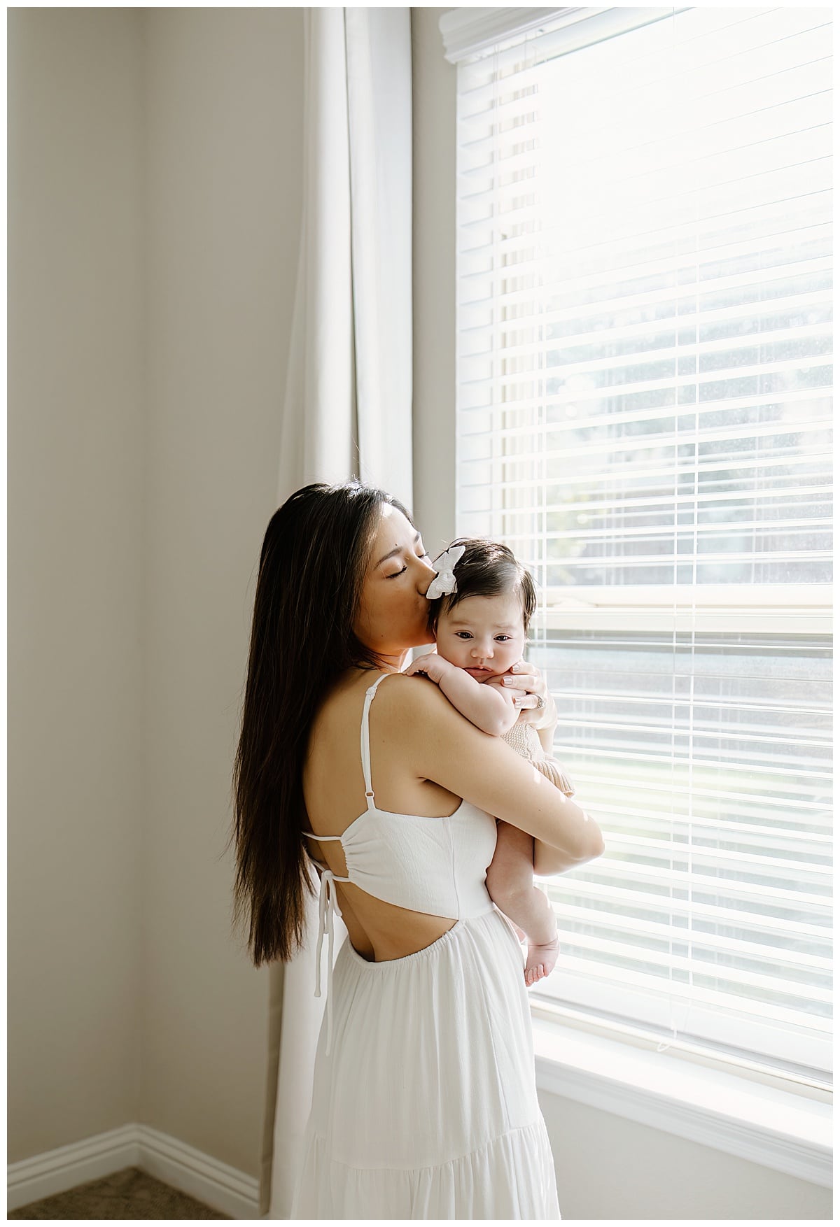 Mom kisses young baby understanding the importance of being able to Document Your Newborn