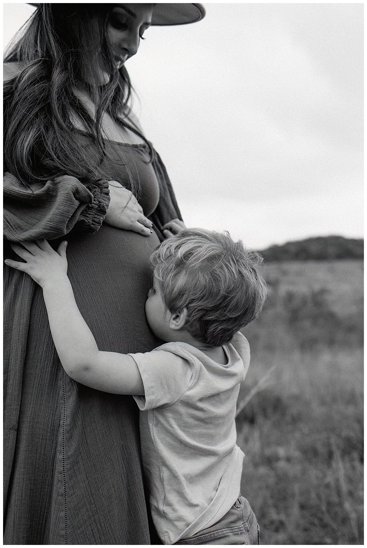 Young boy kisses mom's pregnant belly for Austin Motherhood Photographer