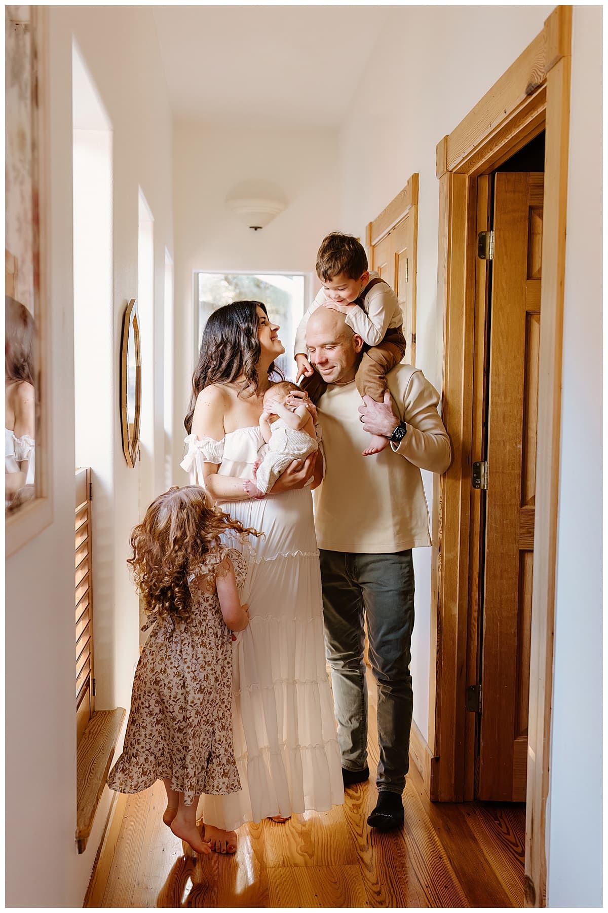 Family smile at each other for newborn photographer