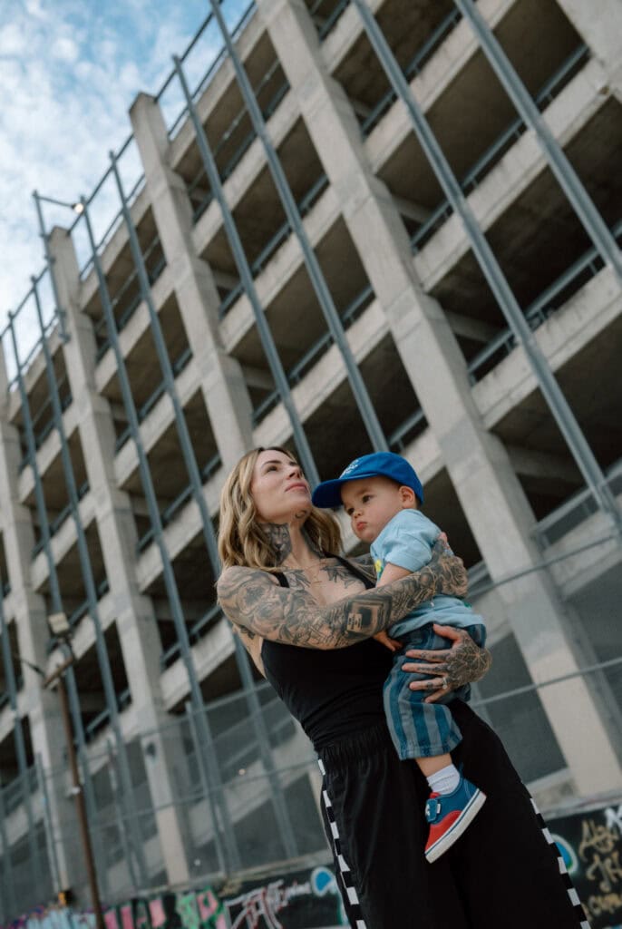 Austin family photographer captures tattooed mother holding her young son outside an urban building.